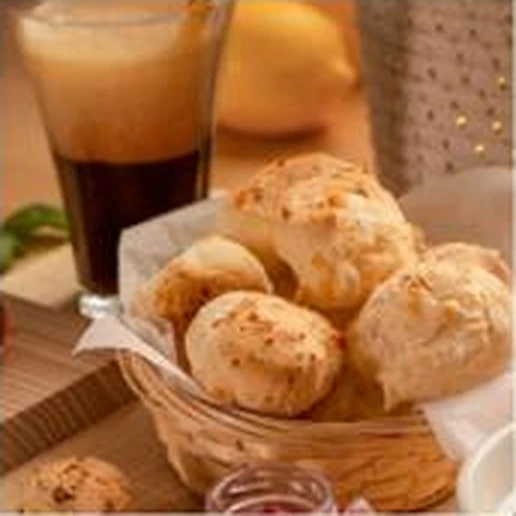 Cesta de pan de yuca junto a un café en un desayuno